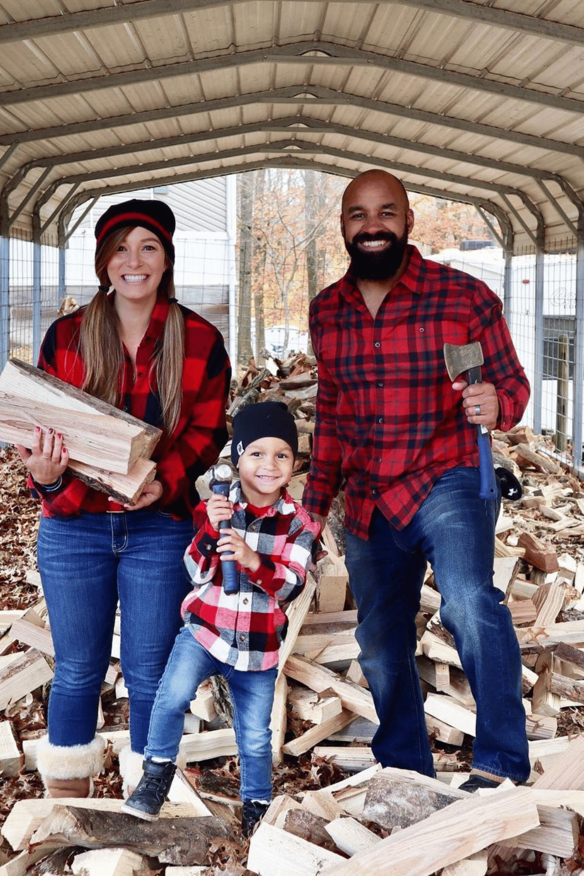 Family dressed in flannel, jeans and carrying axes and chopped wood